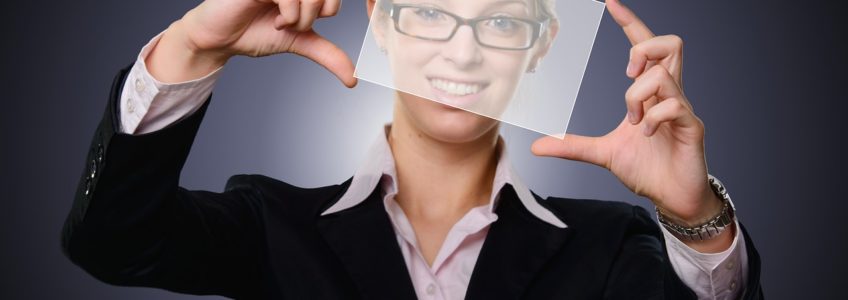 woman holds opaque rectangle in front of face