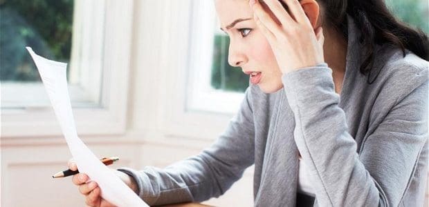 businesswoman hold hand to head and views paper