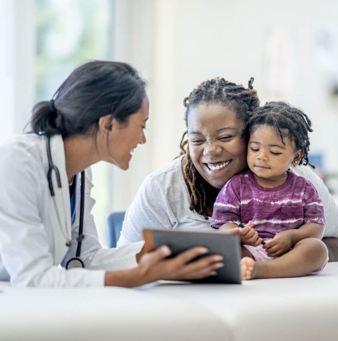 doctor smiles and talks to mother and daughter