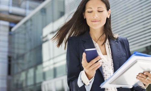 business woman smiles looking at phone