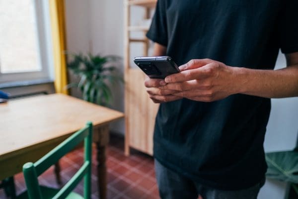 person stands holding phone