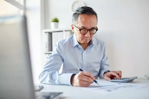 businessman with calculator and papers at office